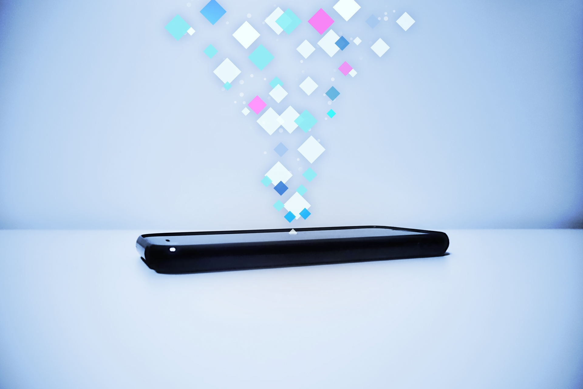 スマホから舞い上がるデータを表すイメージ